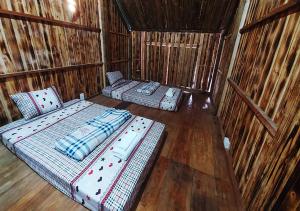河江Quanba Taigoo - HomeStay的稻草小屋内的一个房间里,有两张床
