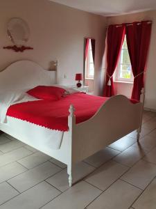 叙尔坦维尔Chambres du logis De La Mare Du Parc的一间卧室配有白色的床、红色床单和红色窗帘