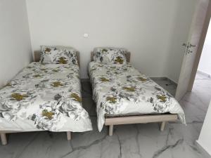 Is-SwieqiSkylark 2 Apartment with Terrace的两张睡床彼此相邻,位于一个房间里