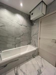 Is-SwieqiSkylark 2 Apartment with Terrace的浴室配有白色浴缸和大理石墙。