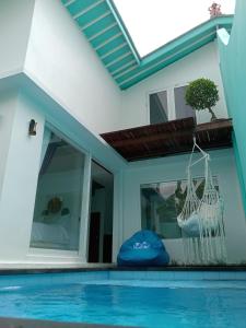 蓝梦岛Villa Giyor的一座房子,设有游泳池和一个靠窗的吊床