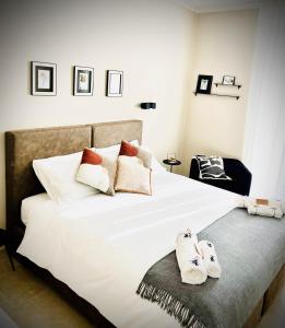 普拉托Lucentum的卧室配有白色的床和拖鞋