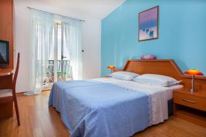 马卡尔斯卡粉红别墅酒店的一间卧室配有一张蓝色墙壁的床