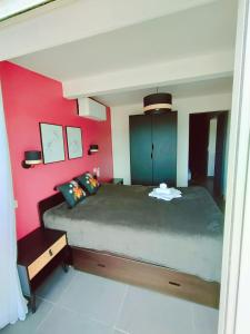 阿格德角Cap d'Agde Naturiste F的一间卧室设有一张大床和红色的墙壁