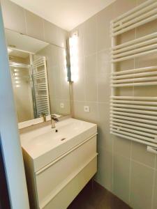阿格德角Cap d'Agde Naturiste F的白色的浴室设有水槽和镜子