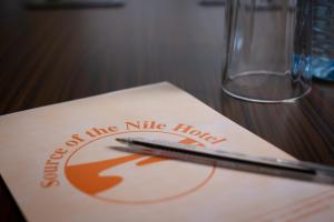 坎帕拉Source of the Nile Hotel - Namanve的坐在餐巾纸上的一个笔