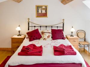 HawardenWoodhouse Cottage的一间卧室配有一张带红色枕头的床