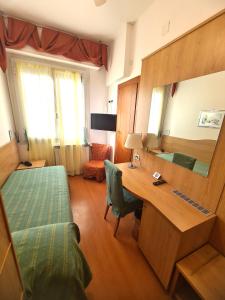 瓦拉泽苏里高酒店的一间卧室配有一张床和一张带镜子的书桌