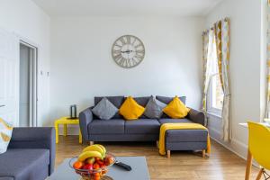滨海绍森德Woodgrange的客厅配有沙发和墙上的时钟
