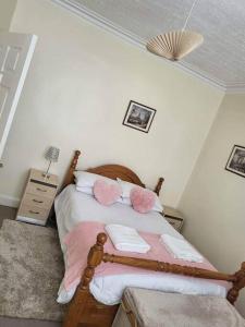 MethilHomely Apartment near the Beach with Mini Luxuries的一间卧室配有带粉色和白色枕头的床
