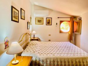 阿尔盖罗Casa Provence Family & Friends Mare & Natura的一间卧室配有一张床和一张桌子上的台灯