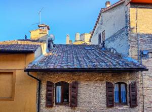 圣吉米纳诺Convento San Gimignano Apartments的一座带窗户和屋顶的旧砖砌建筑