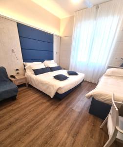 瓦拉泽苏里高酒店的一间卧室设有两张床和蓝色的墙壁