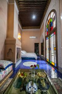 非斯Riad Semlalia的一间设有两张床的房间和一张鲜花桌子
