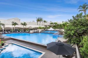 凯恩斯Shangri-La The Marina, Cairns的度假村内带遮阳伞的游泳池