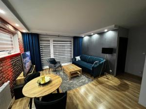 雷达Apartament VIP-2的客厅配有蓝色的沙发和桌子