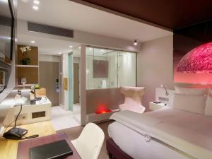 埃因霍温铂尔曼酒店&度假村的一间带一张床和一张书桌的卧室以及一间浴室。