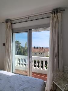 耶尔Villa Marguerite的一间卧室设有一张床,享有阳台的景色