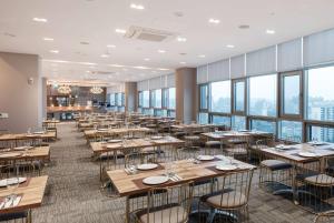 天安市Ramada Encore by Wyndham CheonAn的用餐室设有桌椅和窗户。