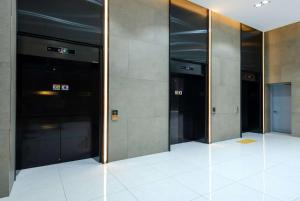 天安市Ramada Encore by Wyndham CheonAn的建筑物的一排电梯门