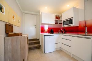 芒格努伊山Absolute Beach的厨房配有白色橱柜和红色墙壁