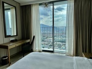 芽庄Handy Panorama Nha Trang Ocean view by HDG的一间卧室配有一张床、一张书桌和一个大窗户