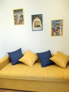 第比利斯Hotel NBL Terrace Rooms的一张沙发,上面有蓝色和黄色的枕头