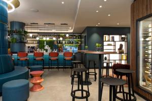 卢加诺LUGANODANTE - We like you的餐厅里设有红色和蓝色凳子的酒吧