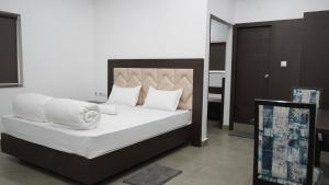 贾姆谢德布尔POD N BEYOND SMART HOTEL @BISTUPUR的一间卧室配有带白色床单和枕头的床。