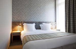 布里德莱班Grand Hôtel des Thermes Brides-les-Bains的卧室设有一张白色大床和一扇窗户。