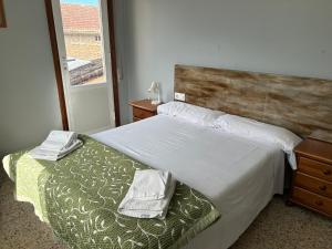 RamallosaPazo Pias P的一间卧室配有一张带木制床头板的床和窗户。