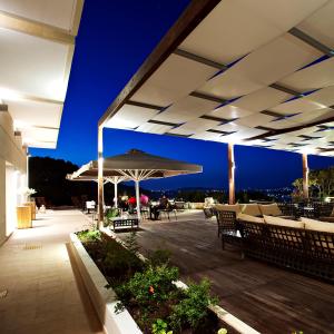 卡塔科隆奥里兹翁特美景酒店的庭院配有遮阳伞和桌椅。