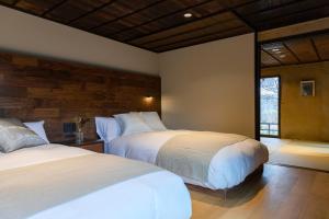 岛原市Hotel mio的一间卧室设有两张床和窗户。