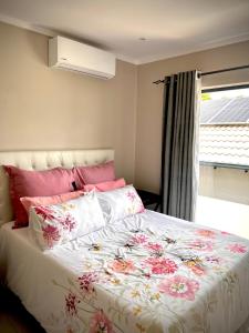 MataffinNo Load-Shedding Holiday Home的一间卧室配有一张带花卉棉被的大床