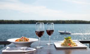 尼亚加拉瀑布尼亚加拉大瀑布福朋喜来登酒店的一张桌子,上面放着两杯葡萄酒和一盘食物