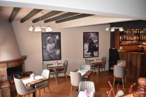 卡兰巴卡Hotel Meteora的一间带桌椅和壁炉的餐厅