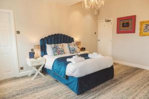 兰卡斯特皇家金斯阿姆酒店的一间卧室配有一张大床和蓝色床头板