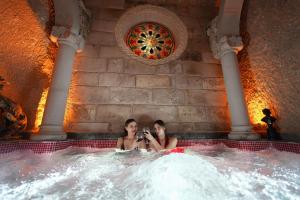 于尔居普Pegas Cave Suites的两个女人在热水浴缸里拍照