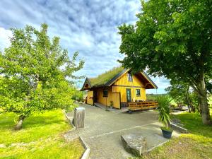SolliSarpsborg Apartments - Utne Camping的一座带草屋顶的黄色小房子