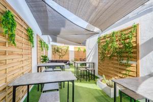 略夫雷加特河畔奥斯皮塔莱特Casa Barcelo Camp Nou Barcelona的配有桌椅的房间和植物墙