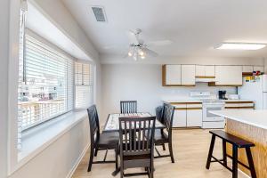 巴克斯顿Egret #6B-CAC的厨房配有餐桌、椅子和窗户。