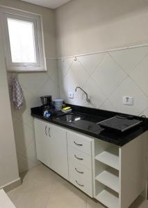 库里提巴POSIT APARTAMENTOS的一个带水槽和窗户的小厨房