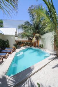 江比阿UVIVU by Jambiani Villas的一座种植了棕榈树的大型蓝色游泳池