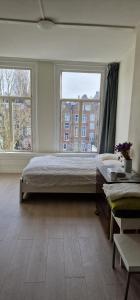 阿姆斯特丹Frank’s and Chong’s excellent location的一间卧室设有一张大床和两个窗户。