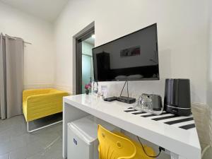 拉纳卡Apollo Rooms by Albert's Apartment的客房设有白色的书桌和墙上的电视
