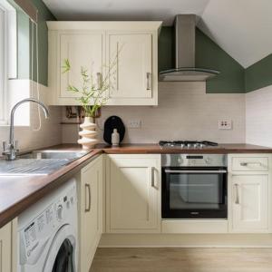 赫默尔亨普斯特德The Bracken's by Ritual Stays的厨房配有白色橱柜、水槽和洗碗机。