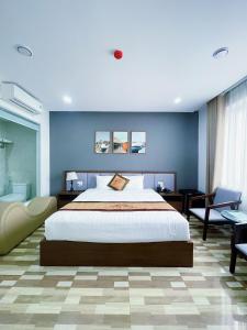 海防Minh Anh Hotel & Apartment的一间卧室设有一张大床和蓝色的墙壁