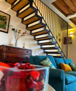 锡耶纳Agriturismo La Corte del Sole的客厅设有蓝色的沙发和楼梯。