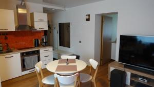 塔林Cozy Telliskivi apartment near city centre的厨房配有桌椅和电视。