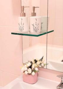 阿拉木图HappyTerra, район ТРЦ "АДК"的浴室水槽上方的玻璃架和鲜花